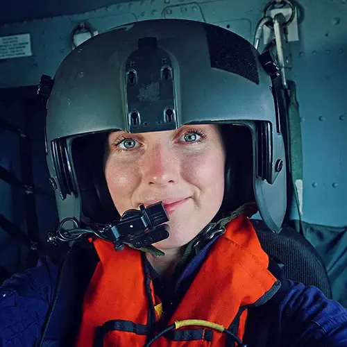 Steenson in a black helicopter helmet with a microphone over her mouth